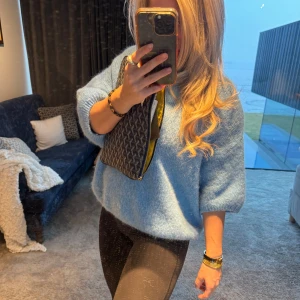 Ljusblå stickad tröja - Säljer en mysig ljusblå stickad tröja med trekvartsärmar. Perfekt för kyligare dagar och ger en avslappnad look. Passar bra till både jeans och leggings.