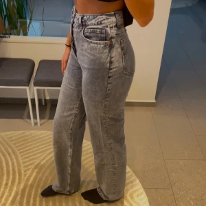 Grå jeans  - Snygga grå jeans med hög midja och en klassisk femficksdesign. De har en rak passform och är perfekta för en avslappnad stil. 