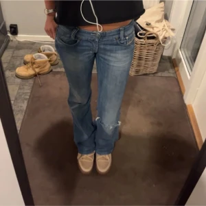 Blå bootcut jeans - Snygga blå bootcut jeans med låg midja. Ett hål vid ena knät, använd sparsamt. Skit snygga W27 L30 Passar bra på mig some 169/170