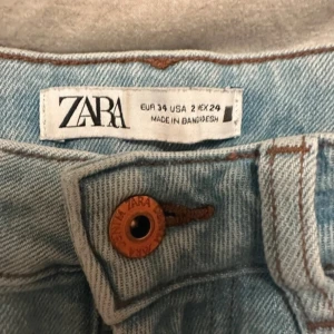 Ljusblå jeans från Zara - Säljer ett par ljusblå jeans från Zara i storlek XS. De har en klassisk design med raka ben och femficksmodell. Perfekta för en avslappnad stil.