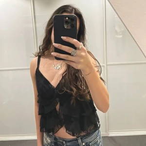 Svart spetslinne med volanger - Supersnyggt svart linne med spetsdetaljer och volanger. Storlek S men passar XS-M. Använd enstaka gånger 🩷💌