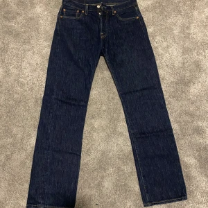 Levis 501 jeans - Klassiska Levis 501 jeans i mörkblå denim. De har en rak passform och är midwaist. Perfekta för en tidlös stil med fem fickor och knappgylf.