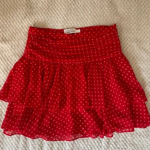 Röd prickig kjol från & Other Stories - Snygg röd kortkjol från & Other Stories med vita prickar och volangdetaljer. Passar mig som vanligtvis har strl 26. Perfekt för en sommaren! (köparen står för frakt!)