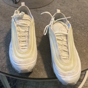 Vita sneakers från Nike - Snygga vita Nike sneakers med snörning och en unik design. Skorna har en synlig luftdämpning i sulan och är perfekta för en sportig look. 