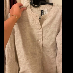 Beige kofta från Divided - Mysig beige kofta från Hm med knappar framtill. Jätte snygg/söt. Mycket bra skick då jag bara har haft den 1 gång 
