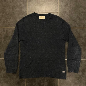 Mörkblå stickad tröja från Denim & Supply - Säljer en snygg mörkblå stickad tröja från Denim & Supply Ralph Lauren. Tröjan har en klassisk rund halsringning och långa ärmar. Perfekt för kyligare dagar och en clean look.