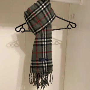 Burberry - Säljer nu denna Snygga halsduk från Burberry i färgen grå. Tillverkad i 100%  mjuk kashmir med klassiskt fransad kant. Perfekt för att hålla dig varm och stilren under kyliga dagar. Hör av er vid funderingar☺️