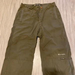 Gröna shorts från Champion - Snygga gröna shorts från Champion med dragkedja och knapp framtill. Perfekta för en avslappnad stil. De har en klassisk design med praktiska fickor.