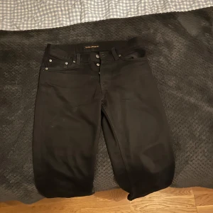 Nudie jeans svarta, W29 L32 - Tjo!! Säljer dessa as feta Nudie jeansen. De är i riktigt bra skick och är riktigt snygga. De passar till mycket och har en bra passform. Nypris 1400, mitt pris 500. Vid funderingar/mer bilder är det bara att kontakta🤩🤩 Snabb affär=lägre pris🤝🤝