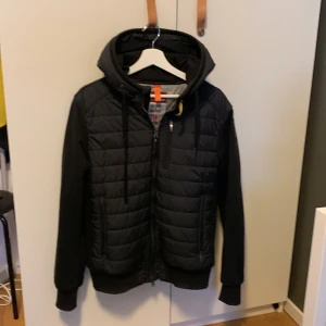Parajumper jacka  - Snygg svart cardigan från Parajumpers. Köpte för 4500kr på Nk förra året. Storlek L men passar M. Väldigt stilren. Helt i nyskick förutom två små brännmärken på luvan och på en av ärmarna. Knappt synligt. Priset är inte hugget i sten och kan tänk mig att gå ner vid snabb affär😃Tveka inte om ni har frågor eller funderingar😉💯