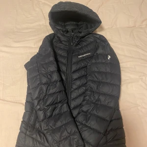 Svart dunjacka från Peak Performance - Säljer en svart dunjacka från Peak Performance med huva och dragkedja. Som ny.
