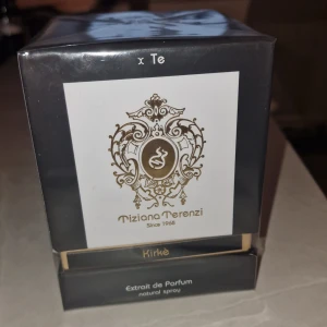 Tiziana Terenzi Kirke Extrait de Parfum - Lyxig parfym från Tiziana Terenzi, Kirke Extrait de Parfum. Förpackningen är elegant med en svart och guldig design, vilket ger en känsla av exklusivitet. Tillverkad i Italien, denna doft är perfekt för den som söker något sofistikerat och unikt.