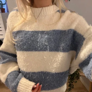 Randig stickad tröja från Pull&Bear - Mysig stickad tröja från Pull&Bear i krämvitt och blått med breda ränder. Är nopprig men ändå super fin!! 