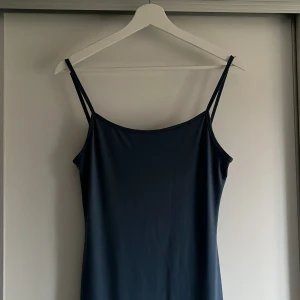Mörkblå långklänning  - Mörkblå långklänning med smala axelband. Sitter lite tajtare och fint på kroppen. 
