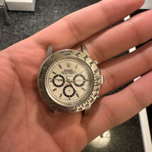 Klocka  - Säljer en klassisk  Oyster Perpetual Cosmograph med en stilren vit urtavla och svarta subdials. Klockan har en silverfärgad . Klockan fungerar om ni har andra frågor de ba ställa ingen garanti eller ångerrätt pris kan diskuteras vid snabb affär 