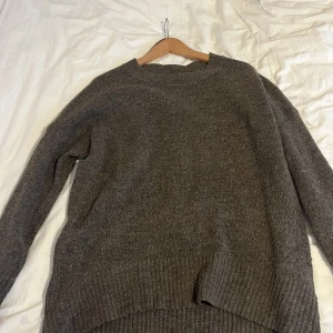 Brun stickad tröja från ONLY - Mysig brun stickad tröja från ONLY med rund hals och ribbade detaljer vid ärmslut och nederkant. Perfekt för kyliga dagar och ger en avslappnad look.