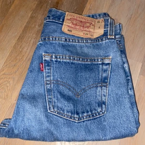 Levi's 501 jeans - Klassiska blå Levi's 501 jeans i 100% bomull. Dessa jeans har en ikonisk design med fem fickor och en rak passform. Perfekta för en tidlös stil. Är för små för mig så kan tyvärr inte visa bild med dem på. 