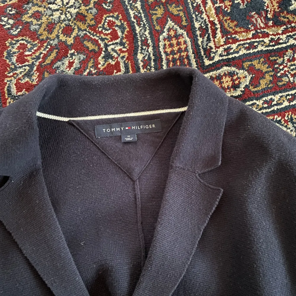 Mörkblå kofta från Tommy Hilfiger. Storlek: M. Skick: 8,5/10, fint skick. Kontakta oss för fler bilder eller info!. Neuletakit & Villapaidat.