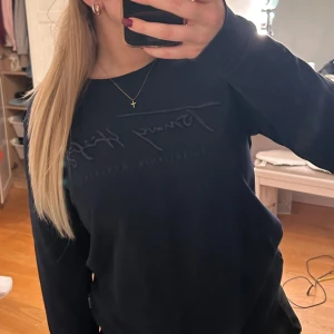 Marinblå tröja från Tommy Hilfiger - Säljer en stilren svart tröja från Tommy Hilfiger med diskret logga på bröstet. Tröjan har långa ärmar och en klassisk rund halsringning. Perfekt för en avslappnad look.