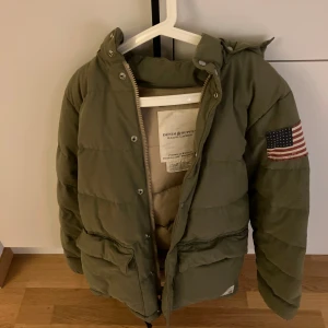 Snygg och varm jacka från Ralph Lauren - Snygg och varm vinterjacka från Ralph Lauren Denim & Supply. Jackan har en mysig avtagbar huva med pälsdetaljer och praktiska fickor. Perfekt för kyliga dagar!