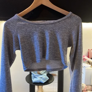 Grå croppad hoodie - Snygg grå croppad hoodie med långa ärmar. Perfekt för en avslappnad stil. Den har en bekväm passform och är tillverkad i mjukt material.