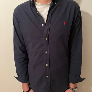 Mörkblå Ralph Lauren skjorta - Riktigt slick mörkblå polo skjorta med rött märke🤠🕺👔🤙!!! Nypris: ca 1499 kr💰 lyxa till vardagen med SlickClothing!🙌