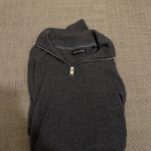 Grå tröja med dragkedja från Jack & Jones - Säljer en stilren grå tröja från Jack & Jones, halfzip. Fint skick och en härlig tröja helt enkelt😆Lätt att matcha med olika outfits. Smidig affär så kan pris diskuteras