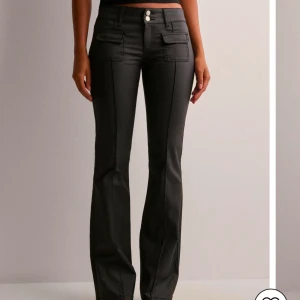 Svarta bootcut byxor med knappar - Snygga svarta bootcut skinnbyxor från Nelly, säljer då de inte satt som jag ville på mig helt nya med prislappen på köptes för 700 säljer för 600 är villig med prisförslag vid snabba köp!🥰