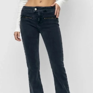 Svarta bootcut jeans pull&bear - Snygga svarta bootcut jeans med låg midja och dragkedjedetaljer vid fickorna. Från pull&bear, inga skador. Storlek 36