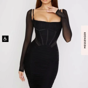 House of cb - Svart klänning med meshärmar - Elegant svart klänning med långa meshärmar och figurnära passform. Klänningen har en korsettliknande överdel med smala axelband och en stilren design som framhäver figuren.