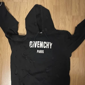 Svart hoodie från Givenchy - Säljer en stilren svart hoodie från Givenchy med vit logotyp på bröstet. Tröjan har en klassisk design med huva och dragsko. Perfekt för en avslappnad look. Hoodien är äkta köpt i dubai. Nypris är runt 6-10 tusen kr. Hoodien är i ny skick använd ett par gånger bara.