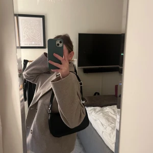 Handväska  - Svart handväska från Monki, köpt för ca 4 år sedan men knappt använd. Justerbart axelband. Ett stort fack i mitten med dragkedja.