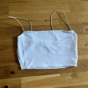 Vit crop top - Vit crop top som sitter tight mot kroppen. Passar bäst om man har lite mindre bröst. Jag kan ha den som har M, men det är knappt. Rekommenderar den om man har S. Har en fläck på baksidan men det ska säkert gå bort i tvätten eller med lite Vanish.