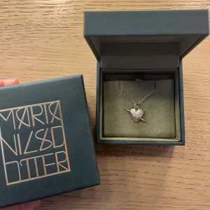 Maria Nilsdotter halsband - Säljer mitt fina Maria Nilsdotter halsband i silver då jag bara använder guld smycken just nu, så kommer ej till användning tyvärr. Använd fåtal gånger därav mycket fint skick!🤩Kvitto och även tillhörande box tillkommer. Nypris: 2800kr