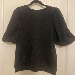 Glitter topp med puff ärmar - Svart glitter topp med puff ärmar. Använd en gång. 