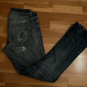 Dondup jeans - Blåa distressed Dondup jeans i bra skick förutom snus märket på bakfickorna. George skinny fit, kom gärna med prisförslag