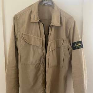 Stilren jacka från Stone Island i färgen beige | Storlek S | Köpt på Stone Island butiken för ca 2 år sedan för ca 4000+ kr | QR kod finns för äkhetsbevis   Skick = 7-8/10 | Ett par pyttesmå prickar som inte syns eller läggs märke till 