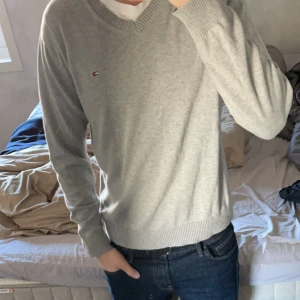 Snygg grå Tommy Hilfiger sweatshirt - Sjukt snygg grå tröja som passar perfekt till ett par jeans nu till hösten.  Endast använd typ 2 gånger eftersom den var lite väl liten på mig. (Modellen är 185 cm och ungefär 75 kg) storleken är M. Vid några funderingar eller fler bilder hör av er!🙏