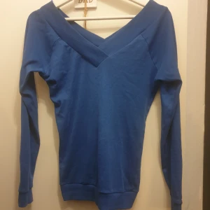 Blå långärmad tröja - Säljer en snygg blå långärmad tröja med en v-ringad design. Perfekt för både vardag och lite finare tillfällen. Den är mjuk och bekväm, och passar bra till jeans eller kjol. Ett måste i garderoben! 💙