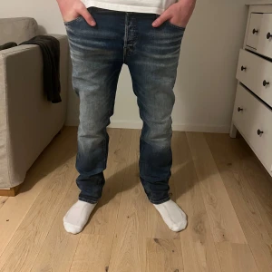 Blå jeans - Snygga blå jeans med en klassisk straight passform. De har en midwaist design och är perfekta för en avslappnad stil. Byxorna har fem fickor och en dragkedja framtill.