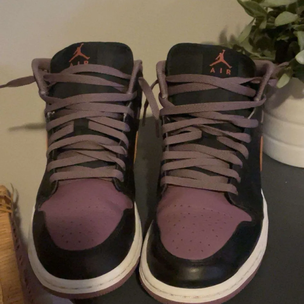 Snygga Nike Air sneakers i svart och lila med orange detaljer. Skorna har en klassisk design med snörning och en bekväm sula. Perfekta för dig som vill ha en stilren look med en färgklick. Inga skador och använda cirka 3 gånger. Pris kan diskuteras!. Kengät.