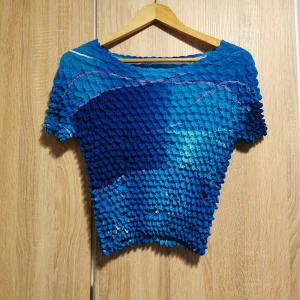 (S/M) Blå texturerad topp, retro, y2k - Unik blå topp med en cool textur och korta ärmar. Finns ingen storleksmärkning, men uppskattas till S/M. Tyget ligger mot kroppen, men känns lös pga att den är sydd för att stretcha enkelt. 💙