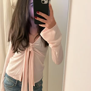 Ljusrosa långärmad topp med knyt - Säljer en söt ljusrosa långärmad topp med knyt framtill. Helt ny. Kontakta för frågor eller köp💝💝