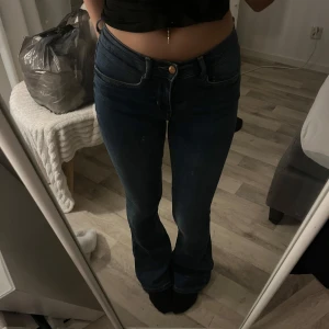 Blå jeans med bootcut - Snygga blå jeans med bootcut-stil. Klassisk design med fem fickor och knappgylf. Perfekta för en avslappnad look. Strechiga och formar kroppen jätte fint! Använda 1 gång