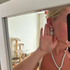 Silvriga blommiga örhängen - Eleganta silvriga örhängen i form av blommor. Perfekta för att ge en glittrig touch till din outfit. De har en vacker design med flera blomblad som reflekterar ljuset fint.