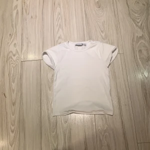 Vit kortärmad t-shirt - Säljer en klassisk vit kortärmad t-shirt i bomull. Perfekt basplagg för alla tillfällen. Enkel och stilren design.