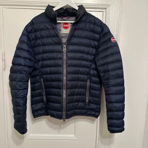 Colmar Jacka - Snygg mörkblå pufferjacka från Colmar med dragkedja. Perfekt för kyliga dagar. Hör av dig vid frågor!