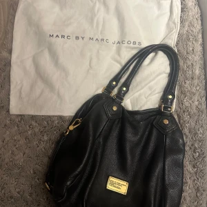 Marc Jacobs väska  - Så fin Marc Jacobs väska! Säljer då den inte kommer till användning längre. Använd och i okej skick, finns några defekter, se bilder! Defekterna märker man inte av, exempelvis hålet ser man knappt och defekterna på banden tänker man inte på. Dust bag medföljer. Pris går att diskutera vid snabbt köp 🥰