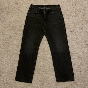 Svarta jeans från Lee - Snygga mörkgråa jeans från Lee med klassisk femficksdesign. De är tillverkade i ett slitstarkt denimtyg. Perfekta för en stilren look.