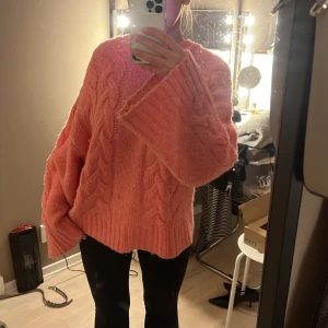 Rosa stickad oversized tröja - Säljer en mysig rosa stickad tröja med kabelstickat mönster från LXA. Tröjan har en oversized passform och är väldigt skön! 
